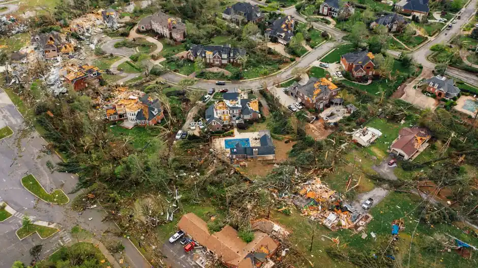 Aerial view of small settlement with destroyed houses and bent uprooted trees after hurricane